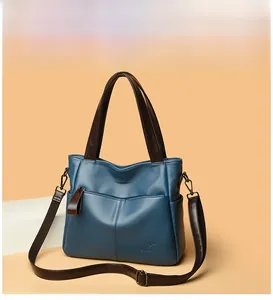 Detail of navy blue pebble leather tote bag with brown handle and BALIDAISHU kangaroo logo