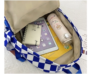 Interior view of checkered backpack showing large capacity for iPad and A4 books
