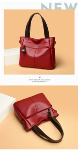 Detail of burgundy leather tote bag showing rich pebble grain texture and handle straps