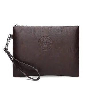 Detail of dark brown leather texture and metal zipper on men's business clutch bag