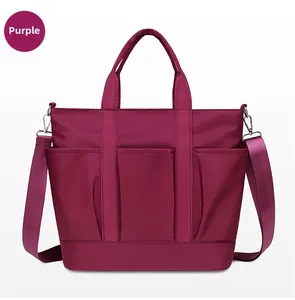 Detailed view of wine red nylon tote bag with multiple front pockets and top handles