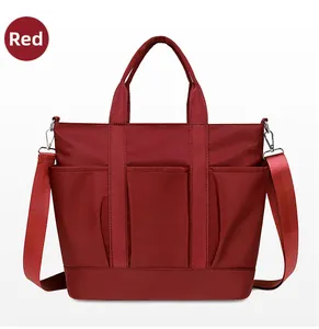 Detail of red nylon tote bag featuring three front pockets and silver-tone hardware