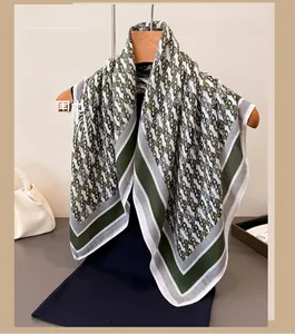 Detail view of olive green and beige vintage chain pattern silk scarf on a hanger