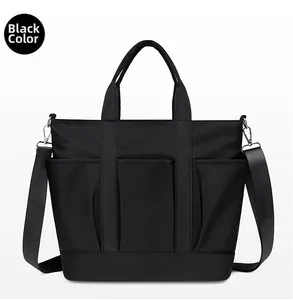 Close-up of black nylon shoulder bag with multiple front pockets and dual handles