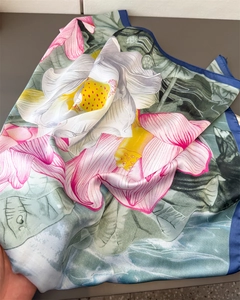 Close-up of ink wash lotus print on large silk scarf with contrast blue rolled edges