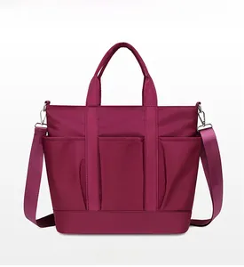 Front view of deep burgundy nylon tote bag with three functional pockets and adjustable strap