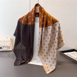 Elegante sciarpa di seta retrò con motivi geometrici marroni e crema su un manichino