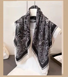 Detail of a lightweight black and white paisley scarf draped on a mannequin
