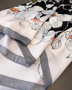 Gros plan détaillé d'un foulard en satin aux imprimés floraux blancs et bords soignés