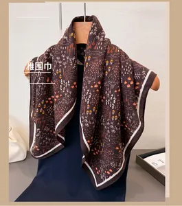 Detail of dark brown scarf with floral patterns on a wooden hanger with blue clothes