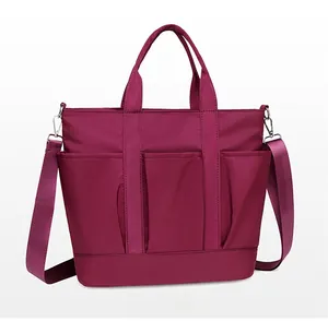Side view of large magenta nylon tote bag with wide adjustable strap and functional pockets