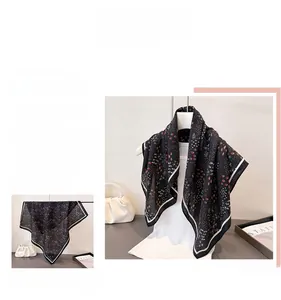 Close-up of black herringbone cotton linen scarf with white border and tiny patterns