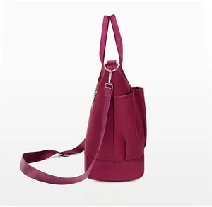 Side view of magenta nylon tote bag showing side pocket and adjustable shoulder strap