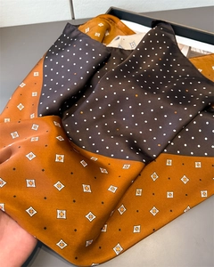 Dettaglio della trama in seta satinata del foulard con motivi a rombi e pois