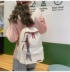 Détail du grand sac à dos en nylon pour étudiants avec des accents rouges et un lapin