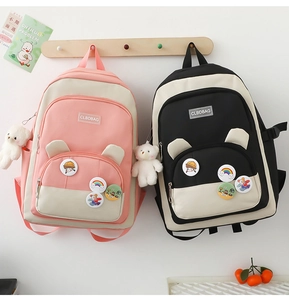 Detail of canvas backpacks featuring colorful contrast panels and cute cartoon charms