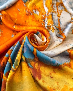 Macro shot of abstract oil painting texture on silk scarf with orange and blue hues
