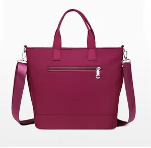Rear view of burgundy nylon tote bag showing zipper pocket and adjustable shoulder strap