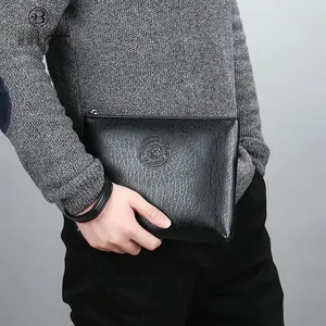Detailed macro view of black PU leather texture with brand logo on casual men's clutch bag