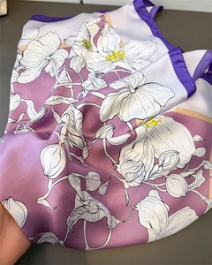 Détail d'un foulard en satin avec imprimés de lys lilas et texture soyeuse élégante