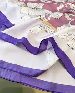 Détail d'un foulard en satin de soie avec imprimé floral violet et texture lisse