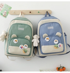 Detail of trendy school backpack with bear ears pocket, cute badges and plush keychain