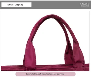 Detail of the reinforced stitching on the durable nylon handbag handle in wine red