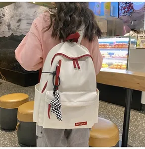 Détail du sac à dos scolaire rouge et blanc avec accessoire charm oreilles de lapin