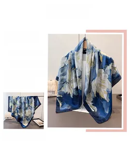 Détail d'un foulard en soie à imprimé floral avec grandes fleurs bleues et drapé élégant
