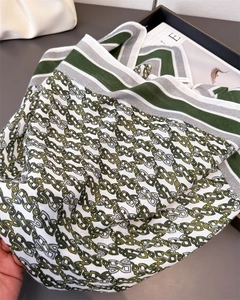 Detail of green and grey chain pattern silk scarf showing soft fabric and elegant texture