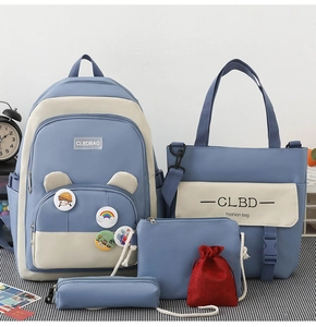 Detail view of 5-piece blue and beige canvas backpack set with badges and matching bags