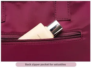 Macro detail of plum nylon shoulder bag featuring a functional back zipper pocket for valuables
