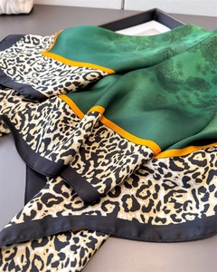 Dettaglio di un foulard in seta con motivi floreali scuri e bordi con stampa animalier leopardo