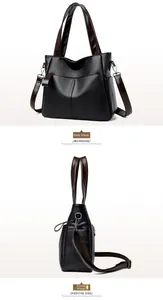 Detail view of black leather tote bag with brown straps and side pocket compartments