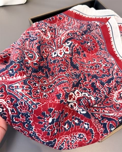 Detail of red and navy paisley print scarf with intricate floral patterns and soft texture
