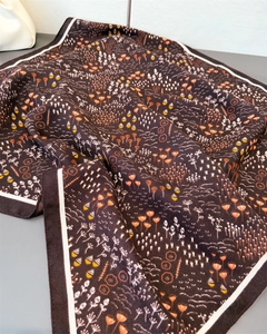 Detail of herringbone linen-feel silk scarf featuring vintage floral prints and white borders