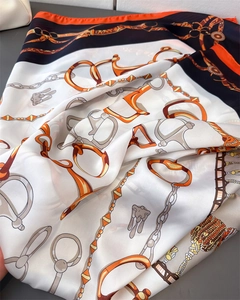 Detail of silk scarf with equestrian horsebit print and smooth satin texture finish