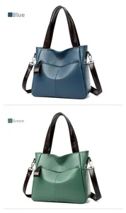Close-up of pebble leather texture and stitched handle on blue and green tote bags