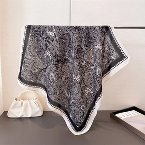 Elegant black and white paisley square scarf hanging with a white pearl handle handbag