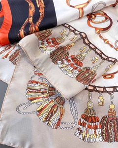 Detail of silk satin scarf showing vintage equestrian patterns and tassel prints