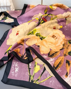 Détail d'un foulard en soie à imprimé floral violet avec fleurs crème élégantes