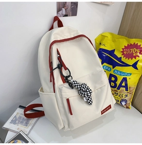 Grand sac à dos en toile blanc crème avec détails rouges et pendentif damier pour école
