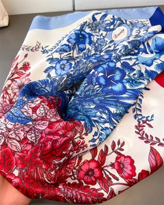 Macro detail of silk-like scarf showing vintage floral patterns and Beauty text print