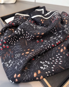 Close-up of black herringbone scarf with elegant white and red floral botanical print