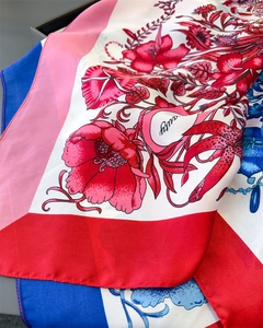 Detailed view of the red and blue floral print scarf showing smooth silk texture