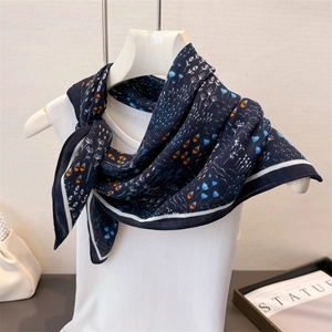 Detail of navy floral cotton linen scarf tied on a mannequin with white ribbed top