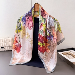Detailed shot of vibrant floral printed silk scarf with fine grey stitched edges