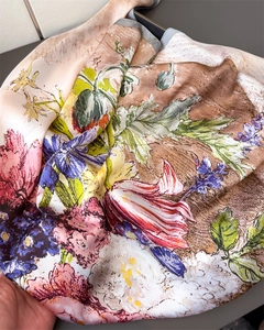 Close-up of vintage floral silk scarf with vibrant colorful prints and soft lustrous texture