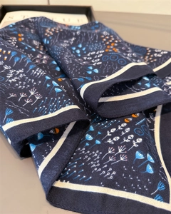 Detailed macro view of the dark blue twill fabric texture and delicate floral patterns