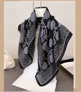 Detail of elegant black and white herringbone scarf with geometric floral pattern on hanger